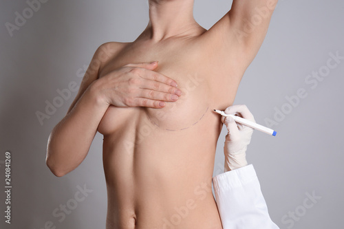 Fotomural Doctor drawing marks on female breast before cosmetic surgery operation against