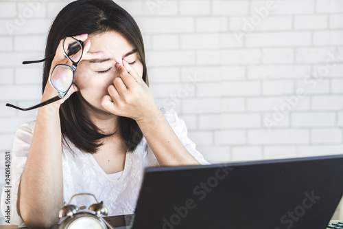 Cuadros en Lienzo Asian woman worker suffering from eye strain taking off her eyeglasses tired fro
