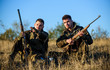 © be free - Discussing catch. Hunters with rifles relaxing in nature environment. Hunter friend enjoy leisure in field. Hunting with friends hobby leisure. Hunters gamekeepers relaxing. Rest for real men concept