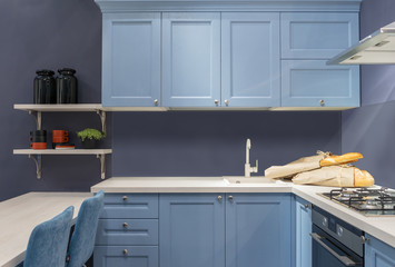 Modern wooden kitchen in the Loft style. Blue furniture with white tabletop, sink and gas stove