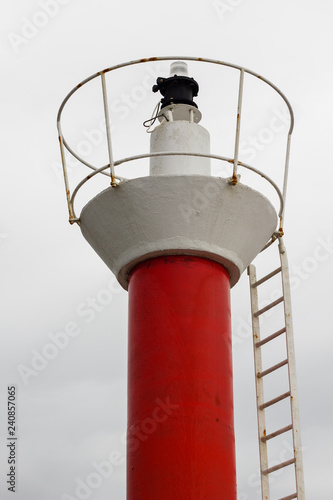 Fotografía Faro rojo y blanco con luz roja de entrada a puerto