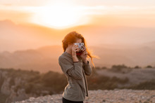 Woman Taking Picture With Vintage Camera During Sunset