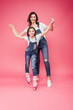 © LIGHTFIELD STUDIOS - beautiful mother teaching daughter rollerblading on pink background