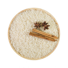 Wall Mural - Raw rice, Rice grian, in bowl isolated with cinnamon and star anise. White rice in wooden bowl on white background, top view.