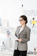 © LIGHTFIELD STUDIOS - attractive businesswoman reading business newspaper in office