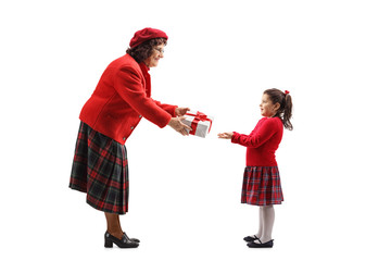 Senior lady giving a present to a little girl