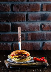 Wall Mural - delicious burger with a knife stuck in a bar