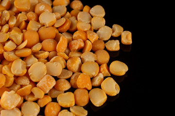 Wall Mural - Yellow chopped peas on a black background close up