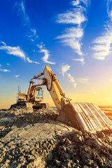 Wall Mural - Excavator work on construction site at sunset