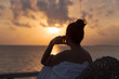 silhouette of a beautiful woman contemplating sunrise from a balcony over the sea