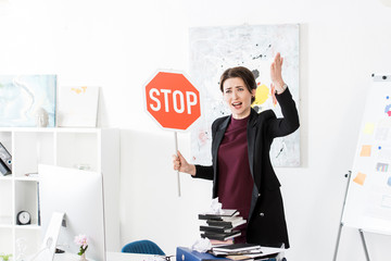 Wall Mural - angry manager holding stop sign and screaming in workplace