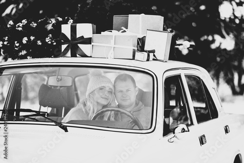A Guy And A Girl Ride In A Retro Car Decorated With A Christmas