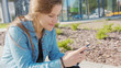 © mputsylo - An attractive young y using a phone in town. Close-up shot. Soft focus