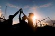© khwanchai - Engineer teamwork, silhouette of construction worker team touching hand together for power at working site