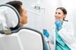 © LIGHTFIELD STUDIOS - smiling female dentist holding drill near patient