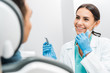 © LIGHTFIELD STUDIOS - smiling female stomatologist holding drill near patient