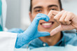 © LIGHTFIELD STUDIOS - selective focus of dentist and african american patient hands making heart shape