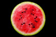 Halbierte Wassermelone isoliert vor schwarzem Hintergrund