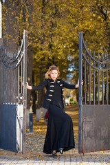 Wall Mural - Young beautiful blonde woman in long black dress