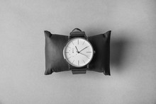Small Decorative Pillow With Stylish Wrist Watch On Gray Background, Top View. Fashion Accessory