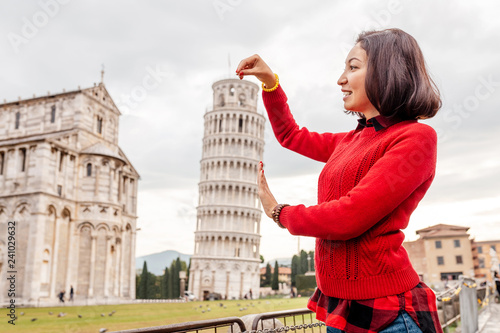 Fotomural Young woman traveler making funny poses in front of the famous leaning tower in Pisa, Italy