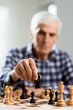 © Goran - Close up of senior man playing chess at home