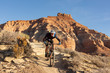 © Melani - A young man rides a mountain bike over a sandstone ledge on the Jem trail in the desert of Southern Utah.