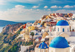 Churches in Oia, Santorini island in Greece, on a sunny day. Scenic travel background.