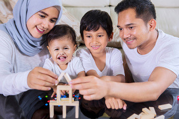 Wall Mural - Happy family build a house with wood blocks