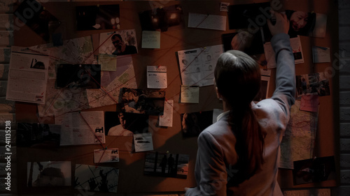 Fotografía Smart detective looking attentively at investigation board, evaluating clues
