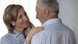 © motortion - Elderly lady with perfect skin looking husband, husband stroking her happy face