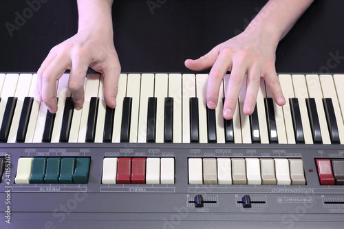 Fotografija A right hand playing a G# sharp (SOL#) major chord on an old black piano with ye