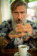 Attraktiver bärtiger Hipster raucht in einem Coffeeshop