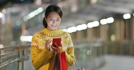 Poster - Woman holding paper and use of mobile phone in city at night