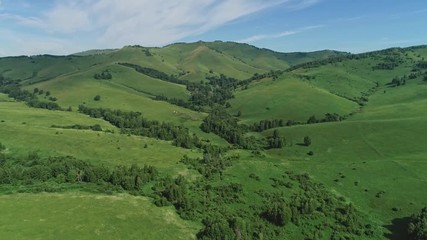 Wall Mural - Aerial footage of long road in the green valley between hills