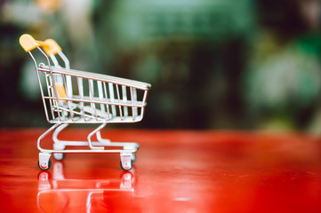 empty yellow shopping cart with supermarket blur abstract background.