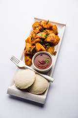 Canvas Print - Masala fried Idlies or Idli fry - south indian Snack made using with leftover idly served with tomato ketchup. selective focus