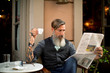 Porträt eines bärtigen Mannes im Cafe Zeitung lesend	