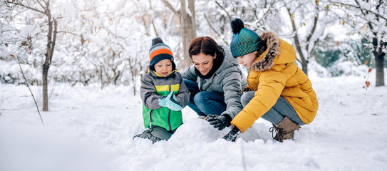 Wall Mural - Family playing in the snow