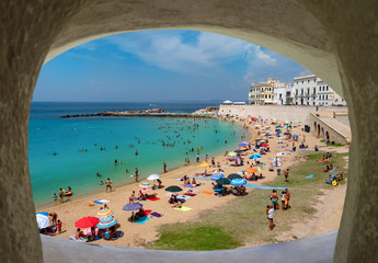 Wall Mural - Wide view of the coastline of Ionian sea and people on the beach in summertime in Gallipoli, Lecce region of Italy