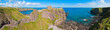 Panorama of a cliff with ancient castle in a bay with blue sky and white clouds in Dunnottar Castle, near Stonehaven, Aberdeenshire