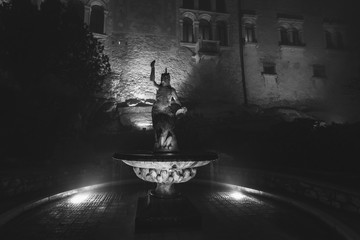 Black and white effect of statue in the garden of ancient monastery transformed into a castle, immersed in the fog, Cison di Valmarino, Italy