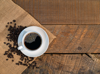 cup of coffee and beans on wooden table