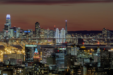 Wall Mural - Oakland and San Francisco Twilight Skylines Illuminated with Holiday Lights. Shot on 2019 New Year's Eve from Oakland Hills, California, USA.