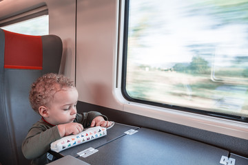 Portrait of a two years old boy playing while traveling in the t