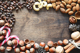 Fototapeta Desenie - Different nuts on a wooden table. Cedar, cashew, hazelnut, walnuts and a spoon on the table. Many nuts are inshell and chistchenyh on a wooden background.