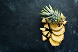 Sliced pineapple on a black background. Tropical Fruits. Top view. Free copy space.