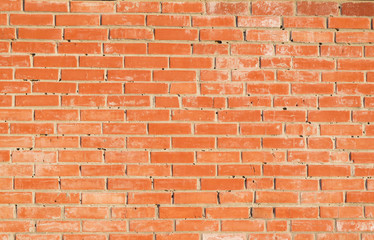 Wall surface texture of orange-brown bricks in frost, close-up, abstract grunge background
