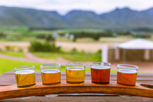 Beer Tasting Glasses On A Wooden Tray Outside The Brewery With A Beautiful View Of The Mountains In South Africa