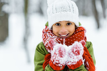 Cute African American Child Showing White Snow An Smiling At Camera In Winter Forest
